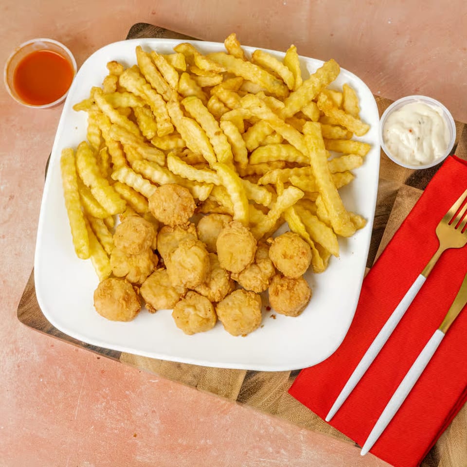 Snappers Fish & Chicken meal with golden fries, fried scallops, and dipping sauces.