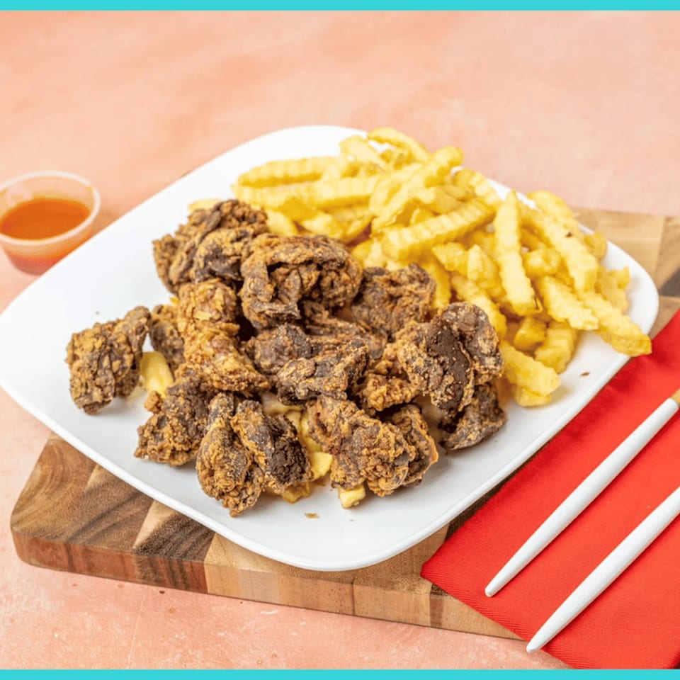 Snappers Fish and Chicken fried gizzards and crinkle-cut fries with a side of sauce.